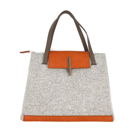 Le Anna n°2 est un sac trapèze en lainage gris  et son dynamique cuir orange